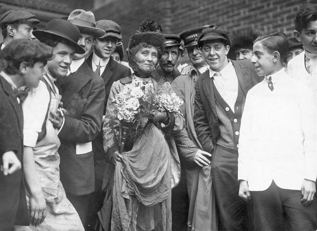 #8 Emmeline Pankhurst standing with a group of men.