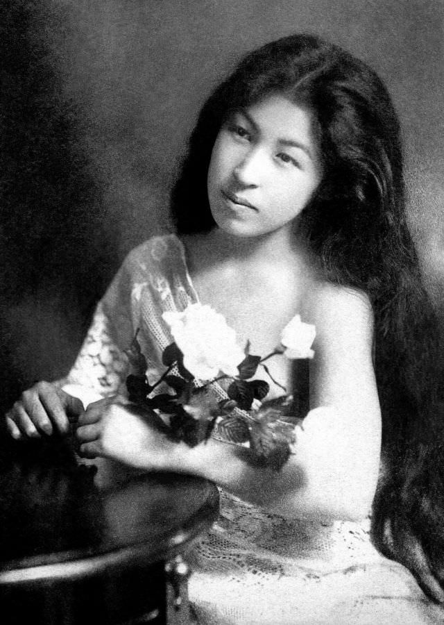 #6 A geisha with her hair down, holding white roses