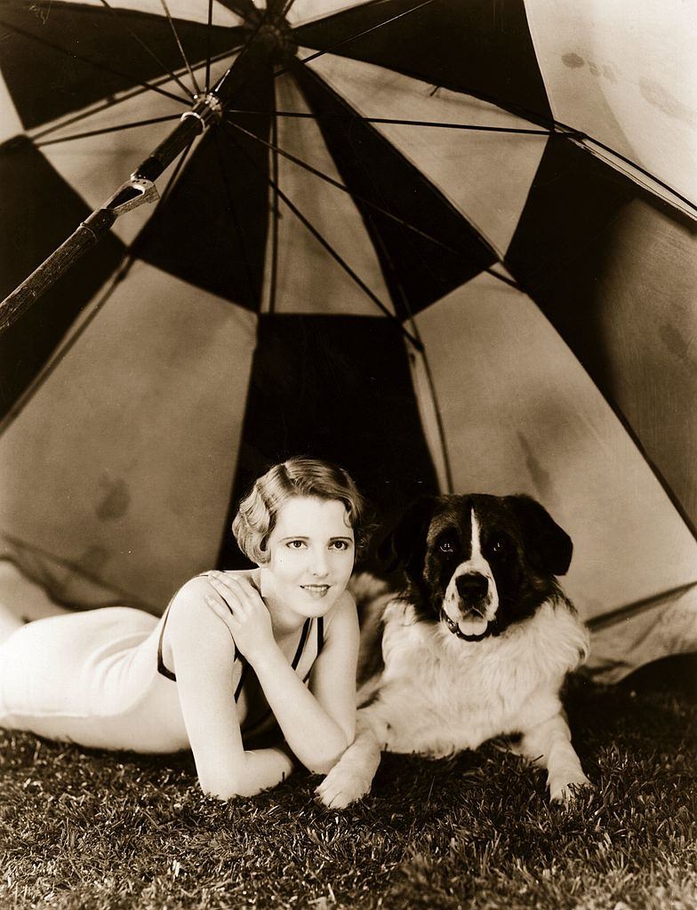 #20 Jean Arthur sitting under an umbrella with ‘Major’, her St Bernard’s dog, 1931.
