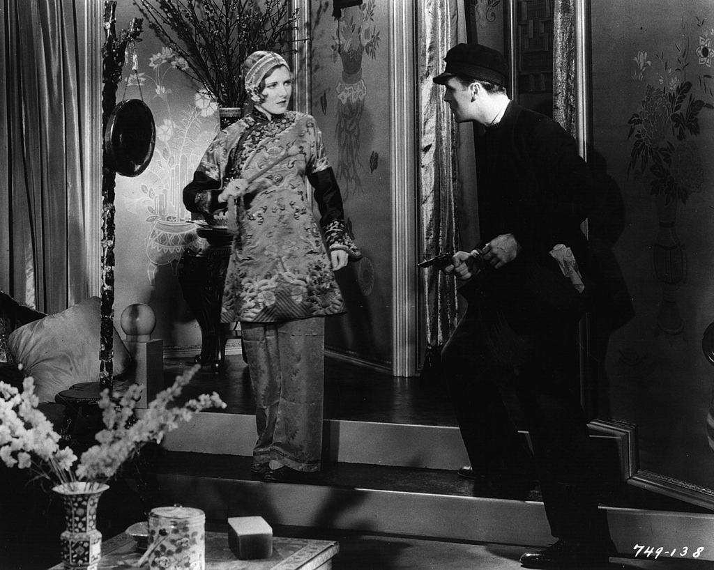 #57 Jean Arthur with Neil Hamilton in an action scene from the film ‘The Insidious Dr Fu Manchu’, 1931.