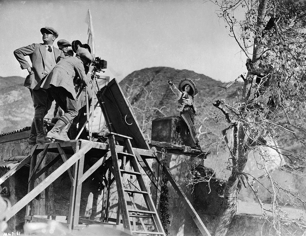 #19 Mae Murray with camera crew shoot a scene on location for the film, ‘Mademoiselle Midnight,’ 1924.