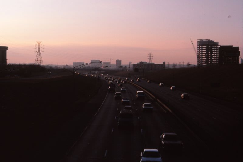 #44 I-494 twilight, the Bloomington Strip. Minnesota Center UC at right, crane for 8400 Normandale visible in center background, fall 1986