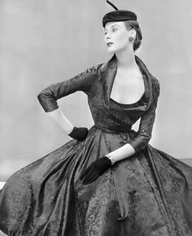 #24 Myrtle Crawford in silk dress with embroidered bodice under fitted bolero with deep shawl collar by Nina Ricci, hat by Claude St. Cyr, 1953