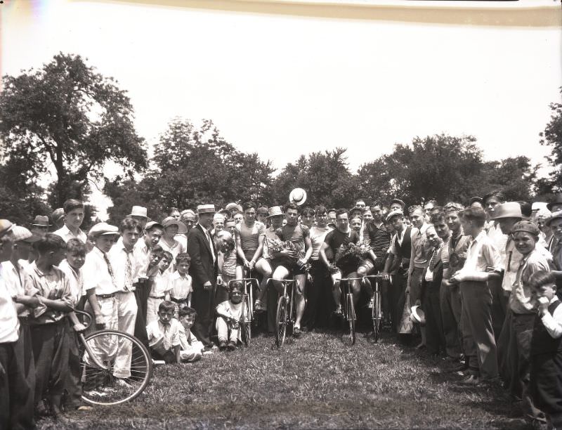 #20 Winners holding flowers after a marathon bicycle race held in O’Fallon Park, June 1931