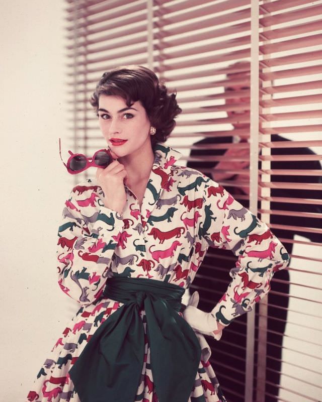 #38 Anne Gunning is wearing fun cotton dress in dachshund motif, 1955