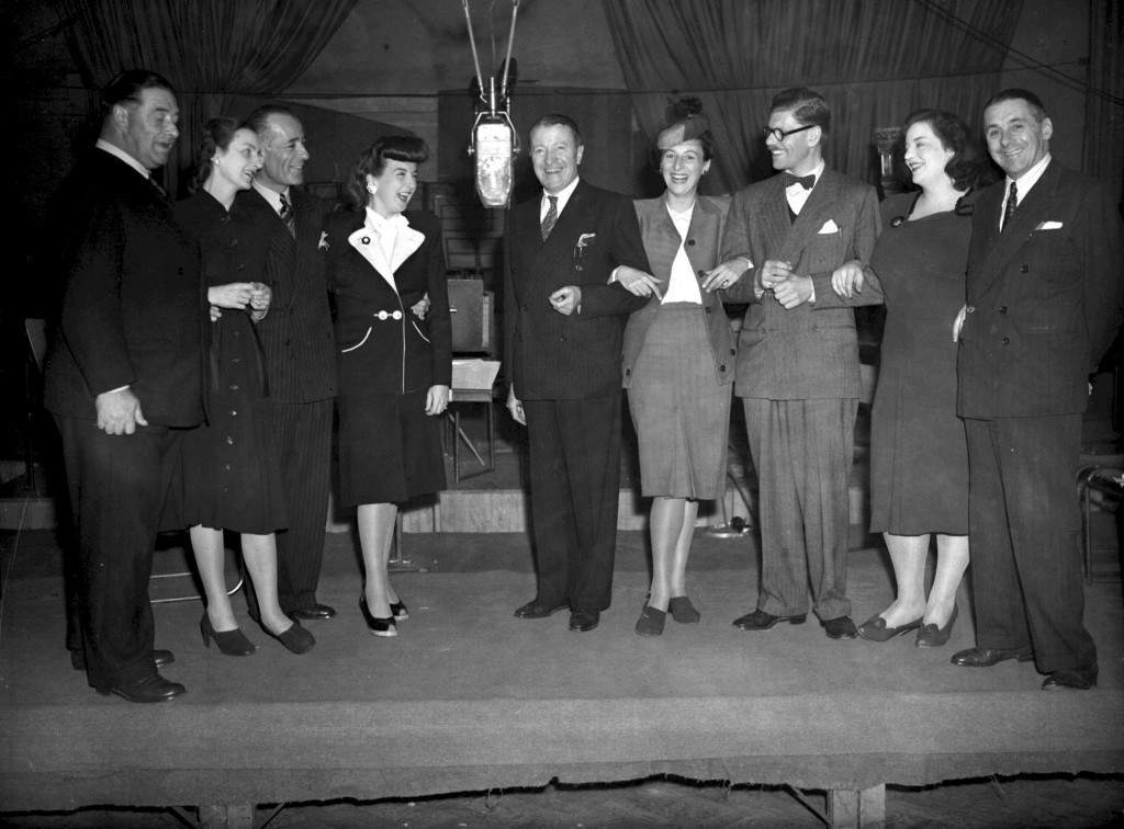 #14 From left to right: Fred Yule, Joan Harben, Hugh Morton, Lind Joyce, Tommy Handley, Diana Morrison, Derek Gyler, Hattie Jackes and Jack Train during rehearsals for the radio show “ITMA” in London.