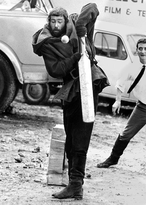 #47 Peter O’Toole dressed for his role as King Henry II, tries his hand at cricket on the French location for “The Lion in Winter 1967