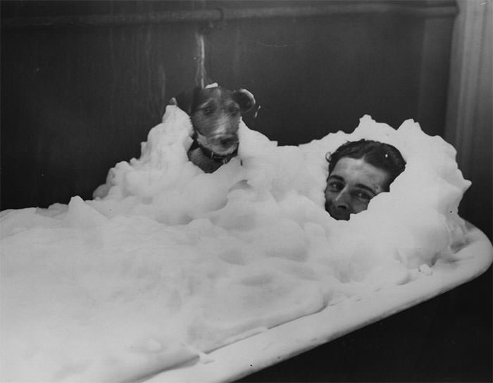 #44 Wally kilminster enjoys a foam bath with his dog in the dressing rooms at wembley stadium, 1934