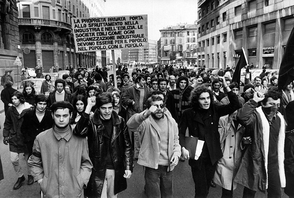 #49 Group of anarchists with black flags demonstrating in Corso Europa, Milan, 1960s.