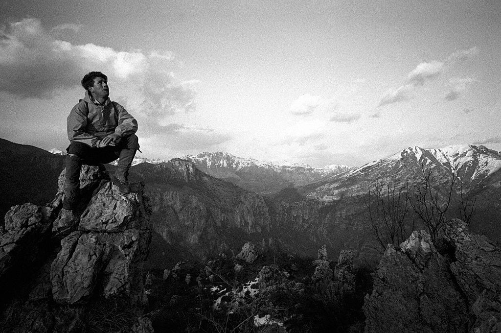 #77 Italian climber and explorer Carlo Mauri sitting on top of a mountain, 1960s.