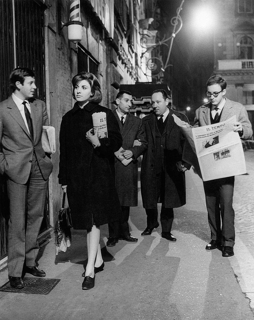 #93 Some young journalist coming back home holding the fresh copies of the newspaper Il Tempo. Rome, 1960s.