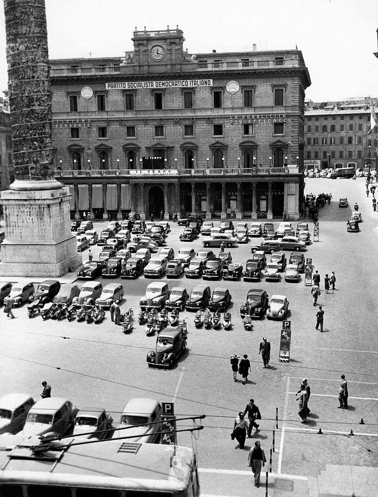 #11 Many cars are parked in front of Palazzo Wedekind in piazza Colonna in Rome, 1960s.