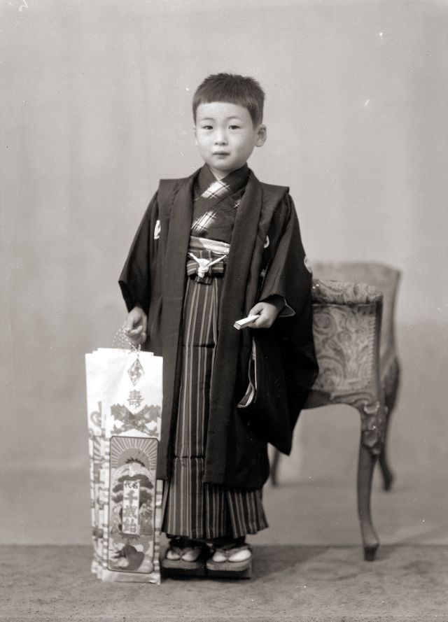 #18 A young Japanese boy in kimono holding traditional Shichi-Go-San candy