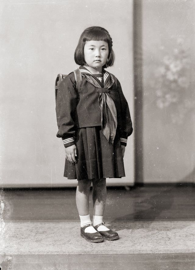 #22 A young Japanese girl in a sailor school uniform with tie and backpack