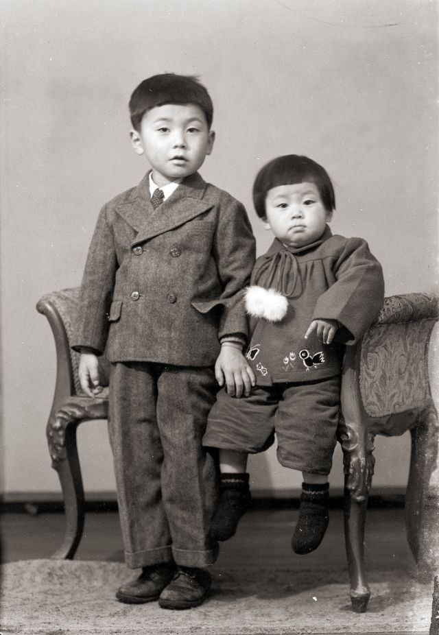 #31 Two Japanese children, one is a suit, posing for a portrait in the old days