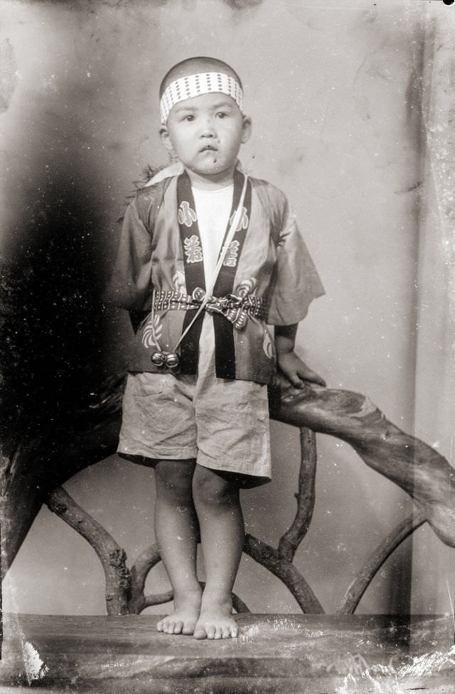 #5 A Japanese boy in a traditional happi coat, a headband, and bells