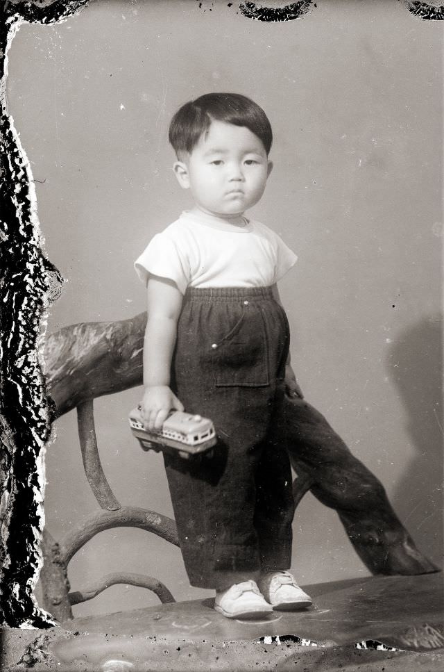 #6 A Japanese boy in very high waist pants and holding a toy train