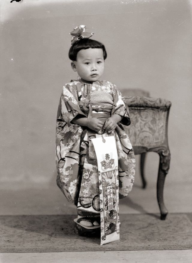 #8 A Japanese child in a kimono with the traditional Shichi-Go-San candy, a hair bow and sandals