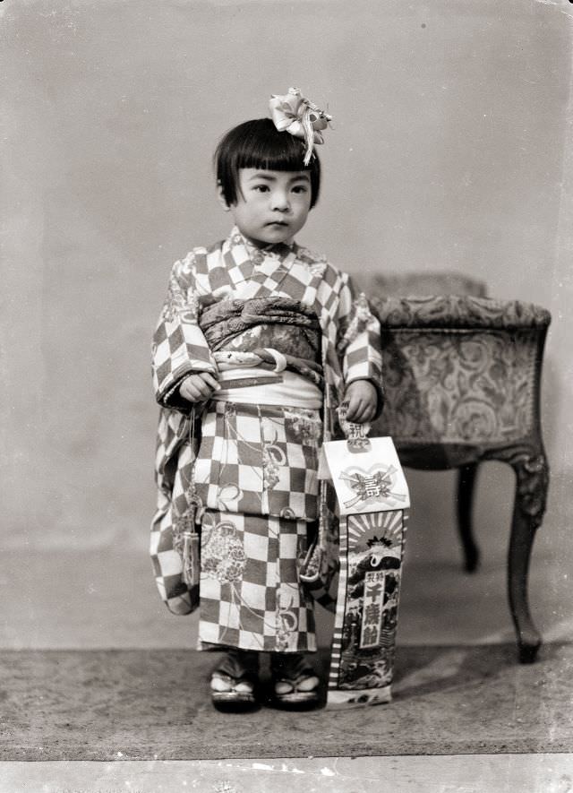 #9 A Japanese girl in a checkered kimono and hair bow with traditional Shichi-Go-San candy