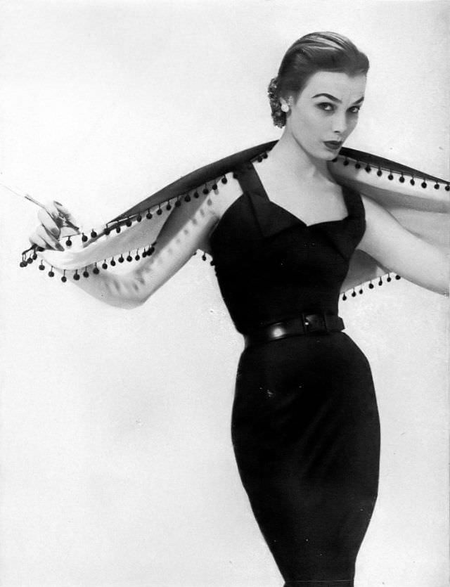 #14 Lillian Marcuson in black silk broadcloth sheath dress with pom-pom trimmed shawl by Edwin, Glamour, April 1951
