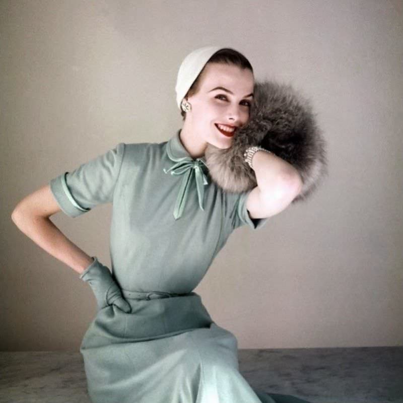 #23 Lillian Marcuson in Heller baby blue worsted jersey dress with satin bow at neck by Richard Cole, little felt hat by Amy and Norwegian blue fox muff by Annis Furs, 1952