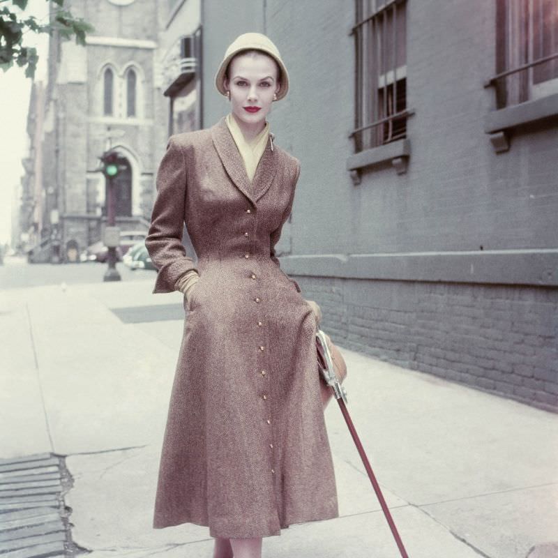 #25 Lillian Marcuson wears a brown coat dress in wool tweed by Vera Maxwell, September 1952