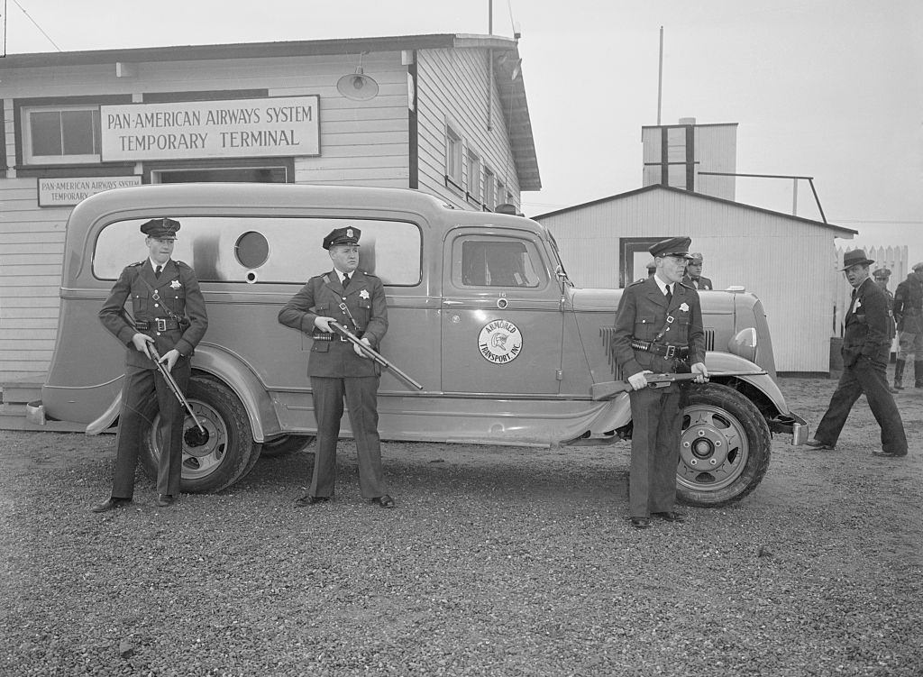 #22 Police guarding trucks containing Panay bombing films at Oakland, 1937.