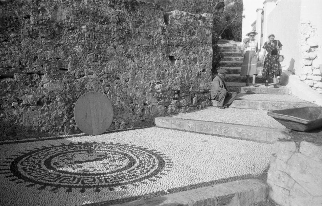 #33 A man and two tourists in an alley of Lindos on Rhodes, Greece, 1950s.