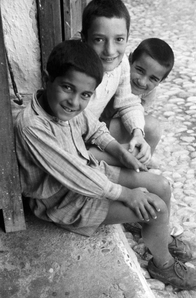 #50 Three boys from the island of Rhodes laugh at the photographer, Greece, 1950s.