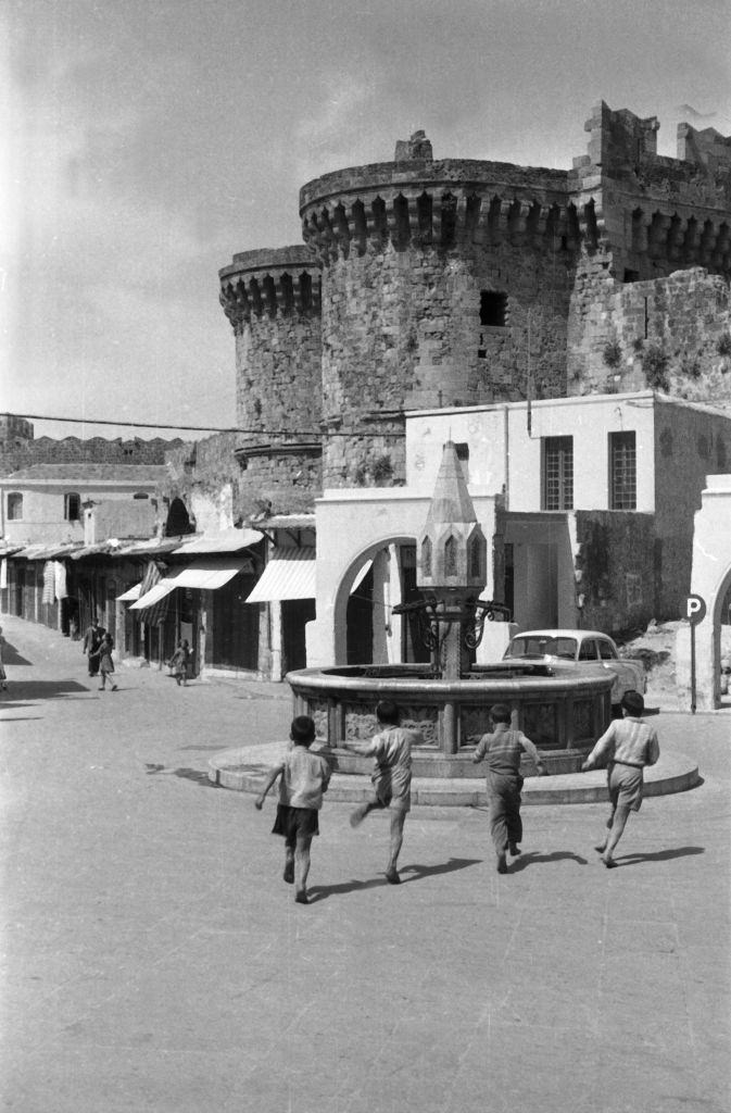 #51 Children run to play to a fountain in Rhodes, Greece, 1950s.