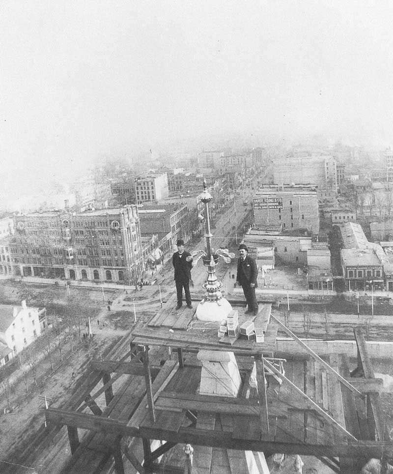 #50 George Albert Smith and temple electrician Ephraim Holding install electric lights on the copper finials on the southeastern tower of the temple.