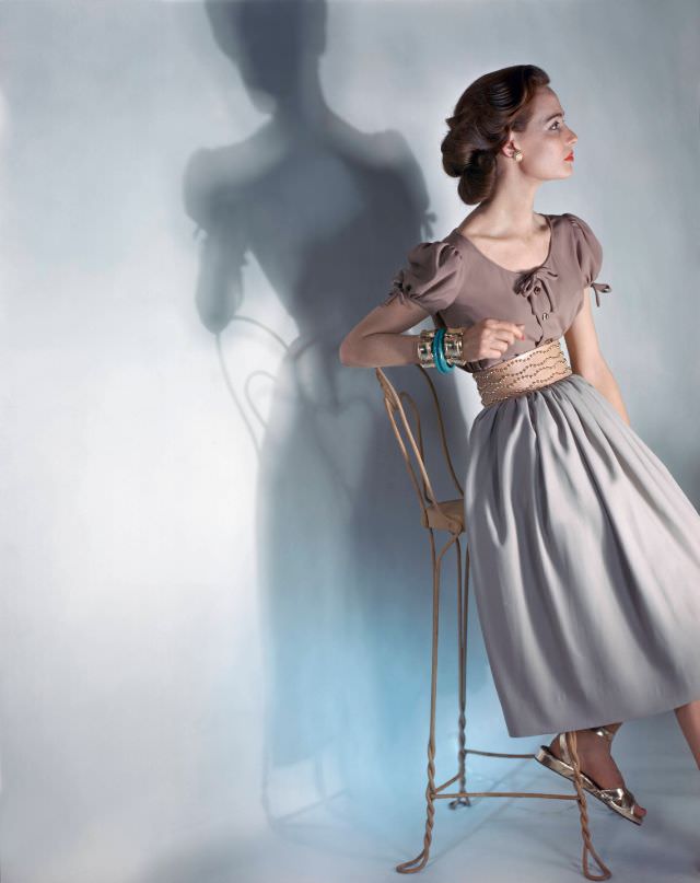 #15 Model in cocoa, short-sleeved blouse and beige skirt, wide leather belt with gold buttons by Criterion, gold sandals, 1946