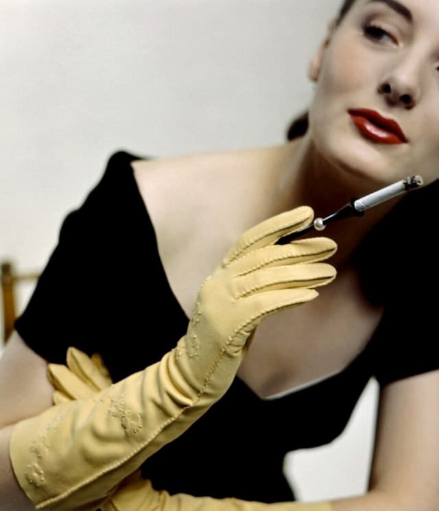 #19 Model is wearing yellow doeskin gloves and cigarette holder by Alfred Orlik, 1946