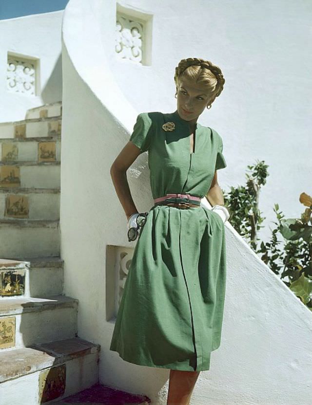 #3 Bijou Barrington in grass-green shantung dress with slot neckline, unpressed pleats, Coro pin, Vogue belts, Glamour, 1945