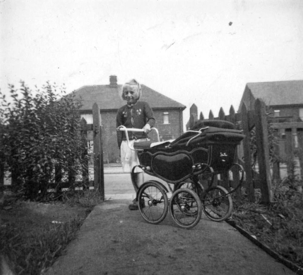 #13 A young girl, a former patient at Stannington Sanatorium, with a dolls’ pram.