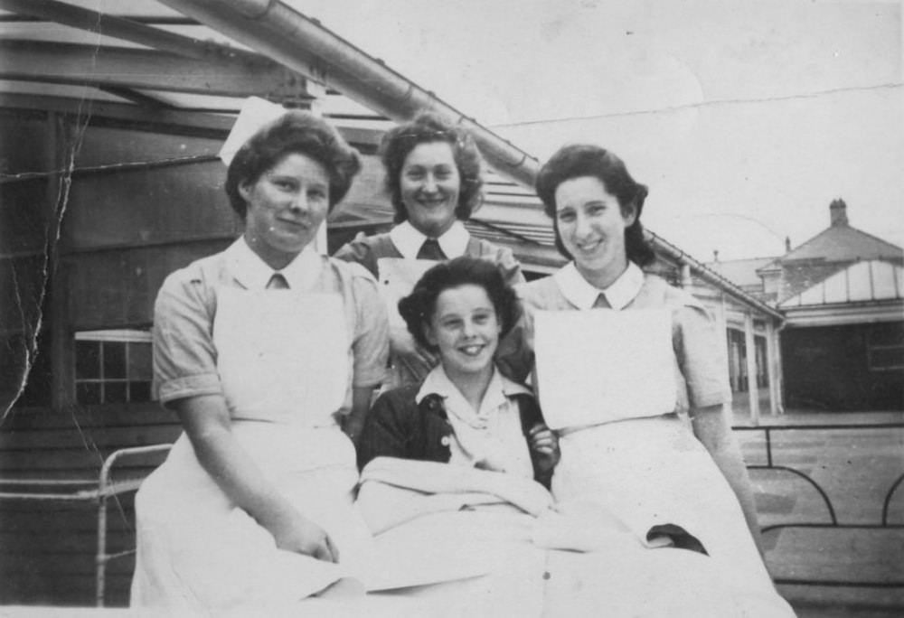 #9 A young patient resting in bed outside, accompanied by three nurses at Stannington Sanatorium, 1946.
