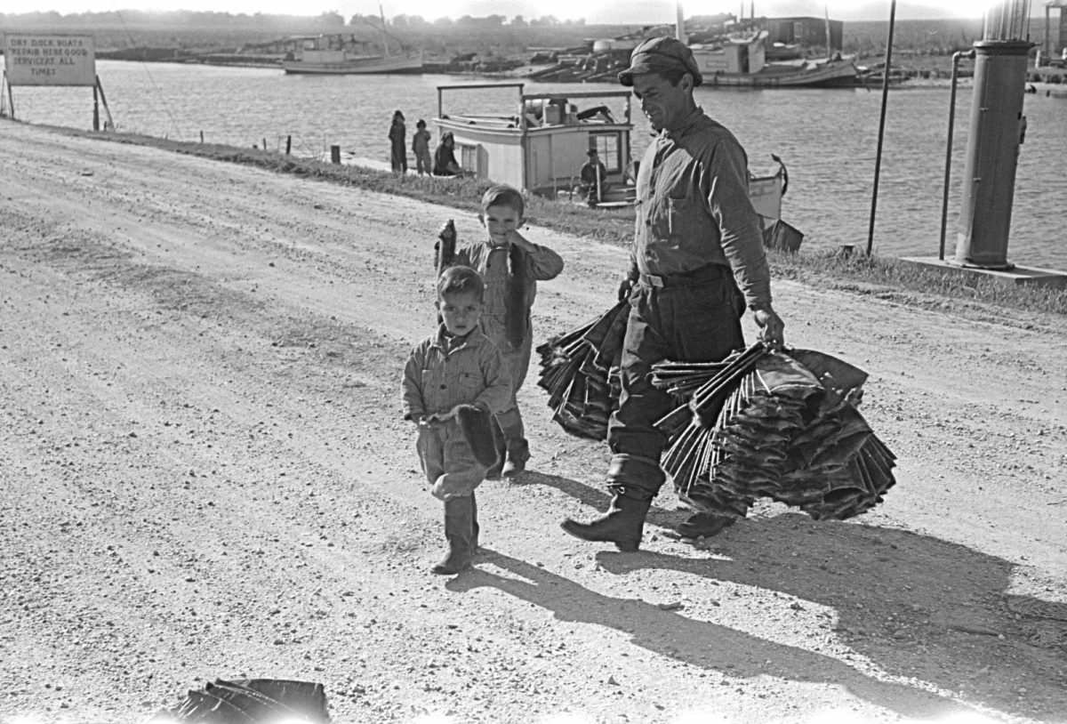 #17 A trapper and his children taking muskrat pelts into the FSA (Farm Security Administration) auction sale held in a dancehall on Delacroix Island, Louisiana, 1941.