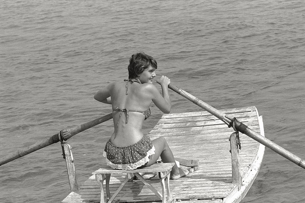 #102 Italian actress Anna Magnani guest at the Film Festival laughs sitting near the actor James Mason. Venice, August 1956.