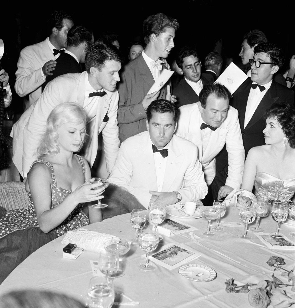 French actress Helene Remy (left) &; Italian actress Gina Lollobrigida (right, also, Milko Skofic, husband of Gina, and Bernard McElwaine Sunday Pictorial Journalist.