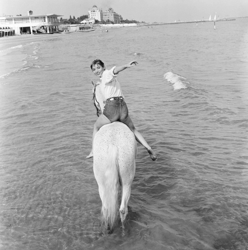 #54 Italian actress and fashion model Elsa Martinelli enjoys a ride in the sea on Bill the horse.