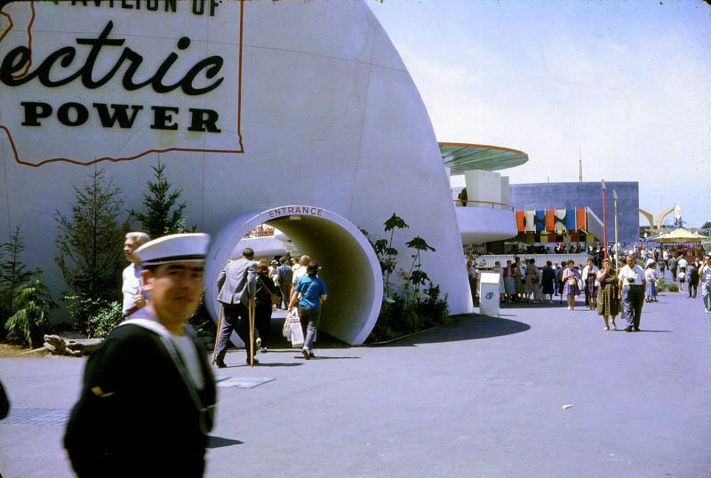 #3 A sailor walks by as a man on crutches enters the Pavilion of Electric Power at the 1962 Seattle World’s Fair