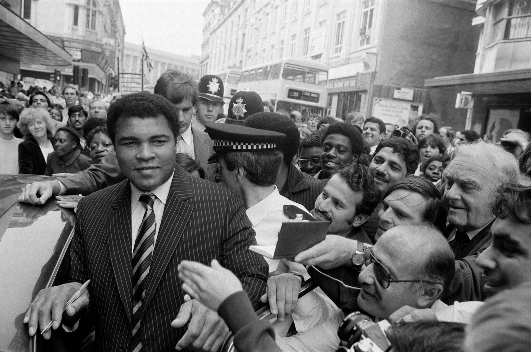 #5 Muhammad Ali is mobbed by fans and supporters in the streets of Birmingham, 9th August 1983.