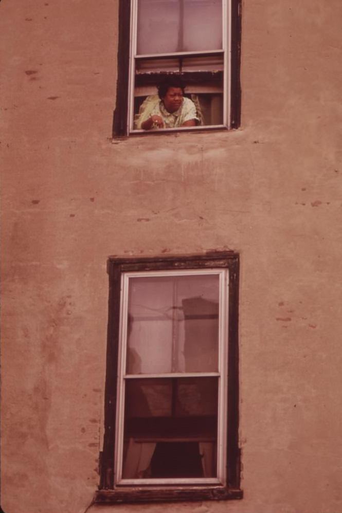 #13 Woman Looks Out Of The Window Of Her Apartment In North Philadelphia, August 1973