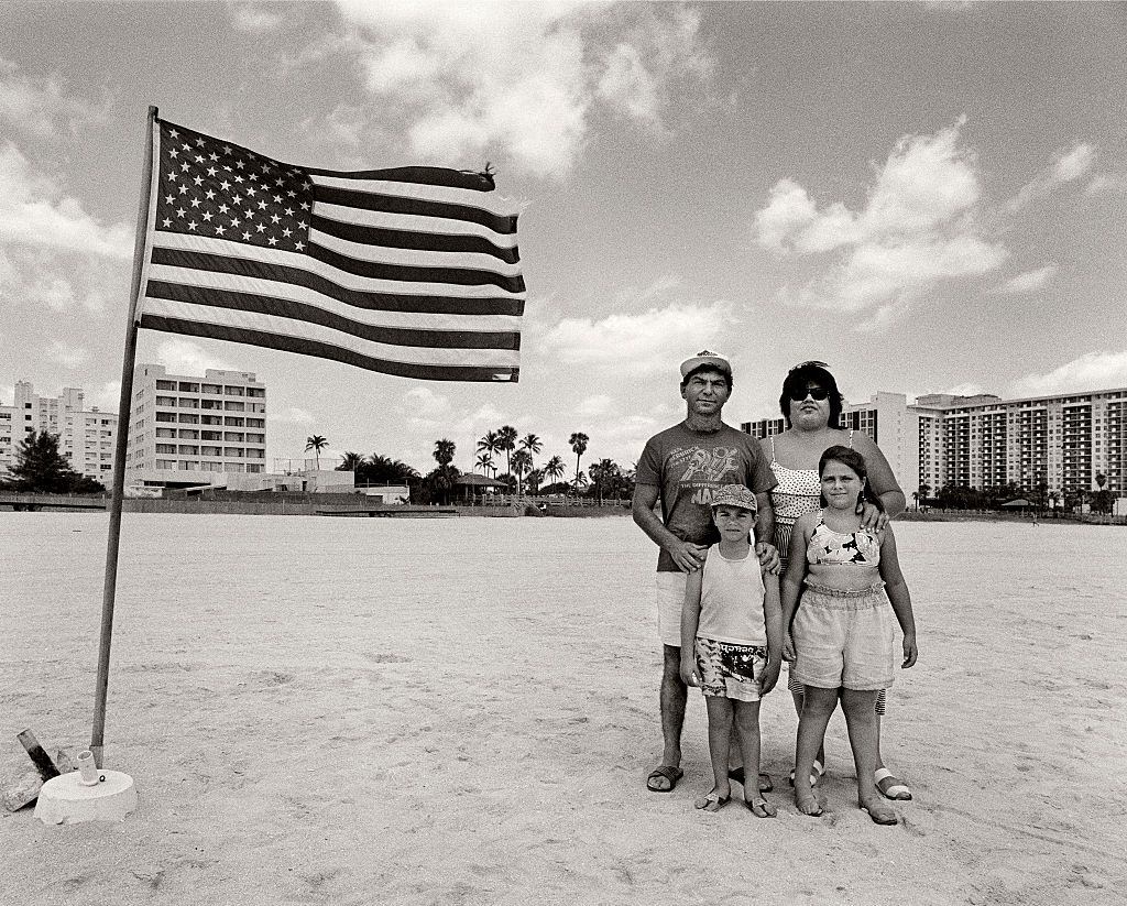#7 Hispanic family posing next to the American Flag on Miami Beach.