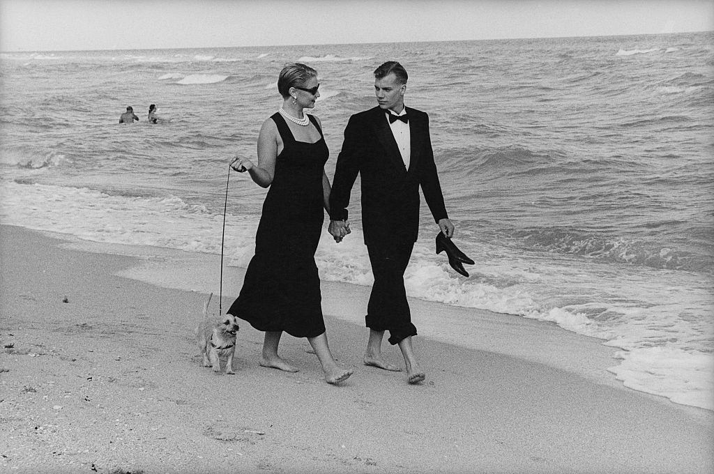 #59 A couple in formalwear strolling hand-in-hand on Miami Beach, Florida, 1990s.