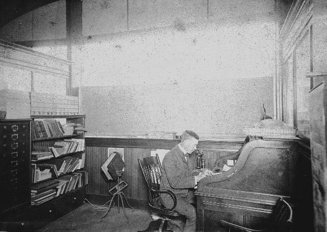 #23 Bernard W. McKenzie seated at a desk in the Western Metal Supply office, 1893