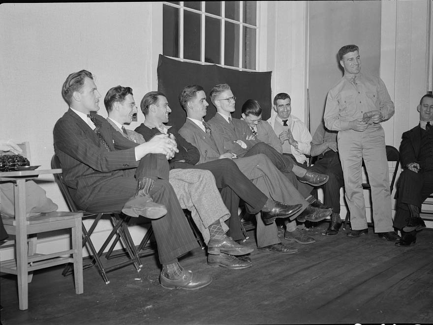 #38 A group of young men soon to leave for army induction camps are listening to William Mongelo, of the U.S. Army Air Corps,1942