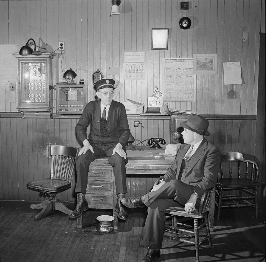 #46 Thomas J. Murphy, chief of the fire department, and its only salaried member, chatting with one of the volunteers, 1942