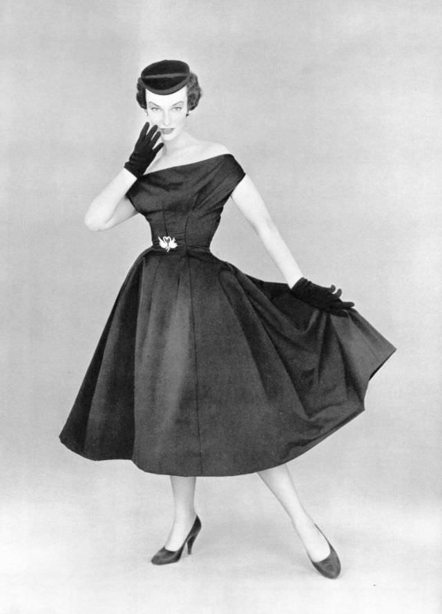 #21 Victoria von Hagen in black satin party dress worn with small velvet cap by Christian Dior, 1953