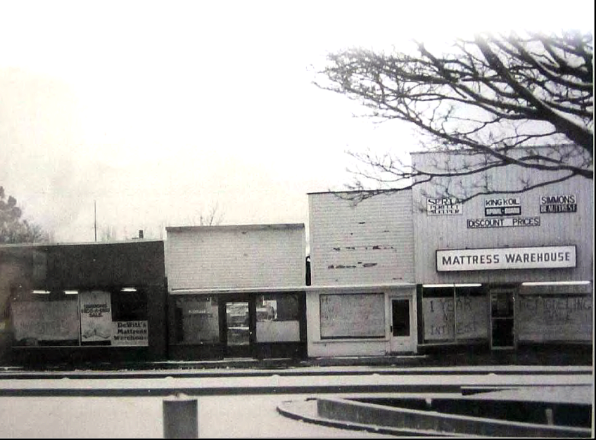 #95 1970s view showing storefronts across from fountain in fountain district